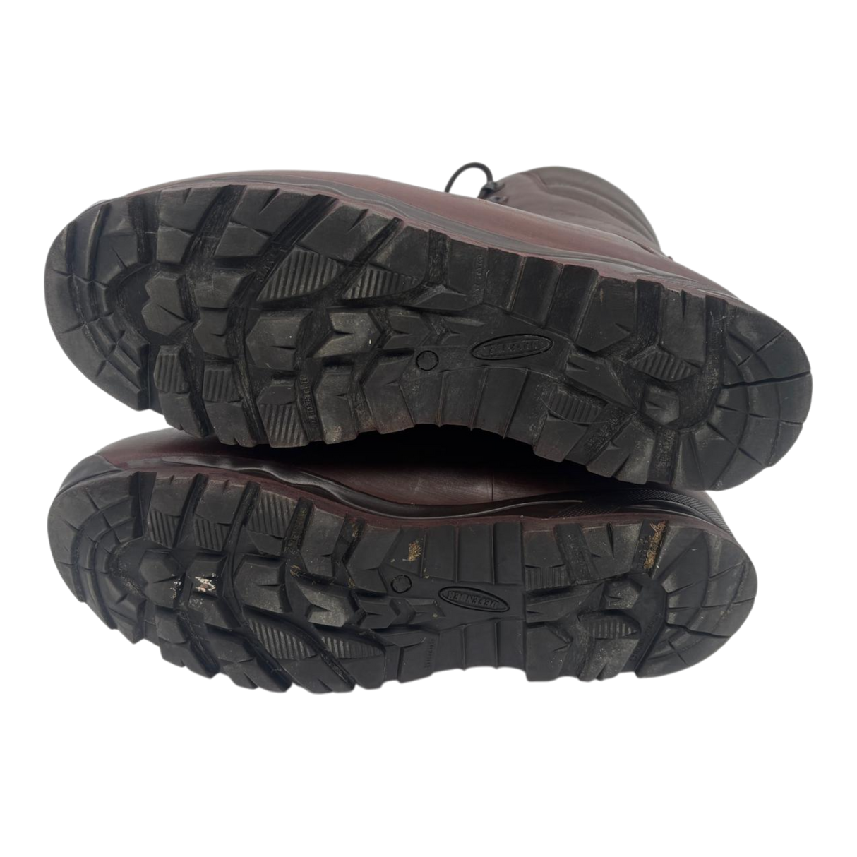 Underside of a pair of brown Karrimor SF combat boots, showing deep-tread rubber soles with Defender markings.