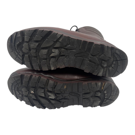 Underside of a pair of brown Karrimor SF combat boots, showing deep-tread rubber soles with Defender markings.
