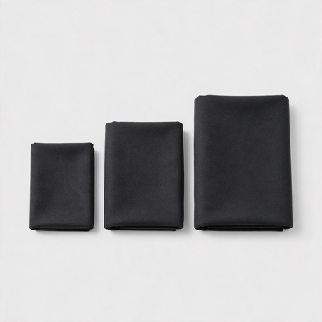 Three black microfibre towels folded side by side showing small, medium and large sizes